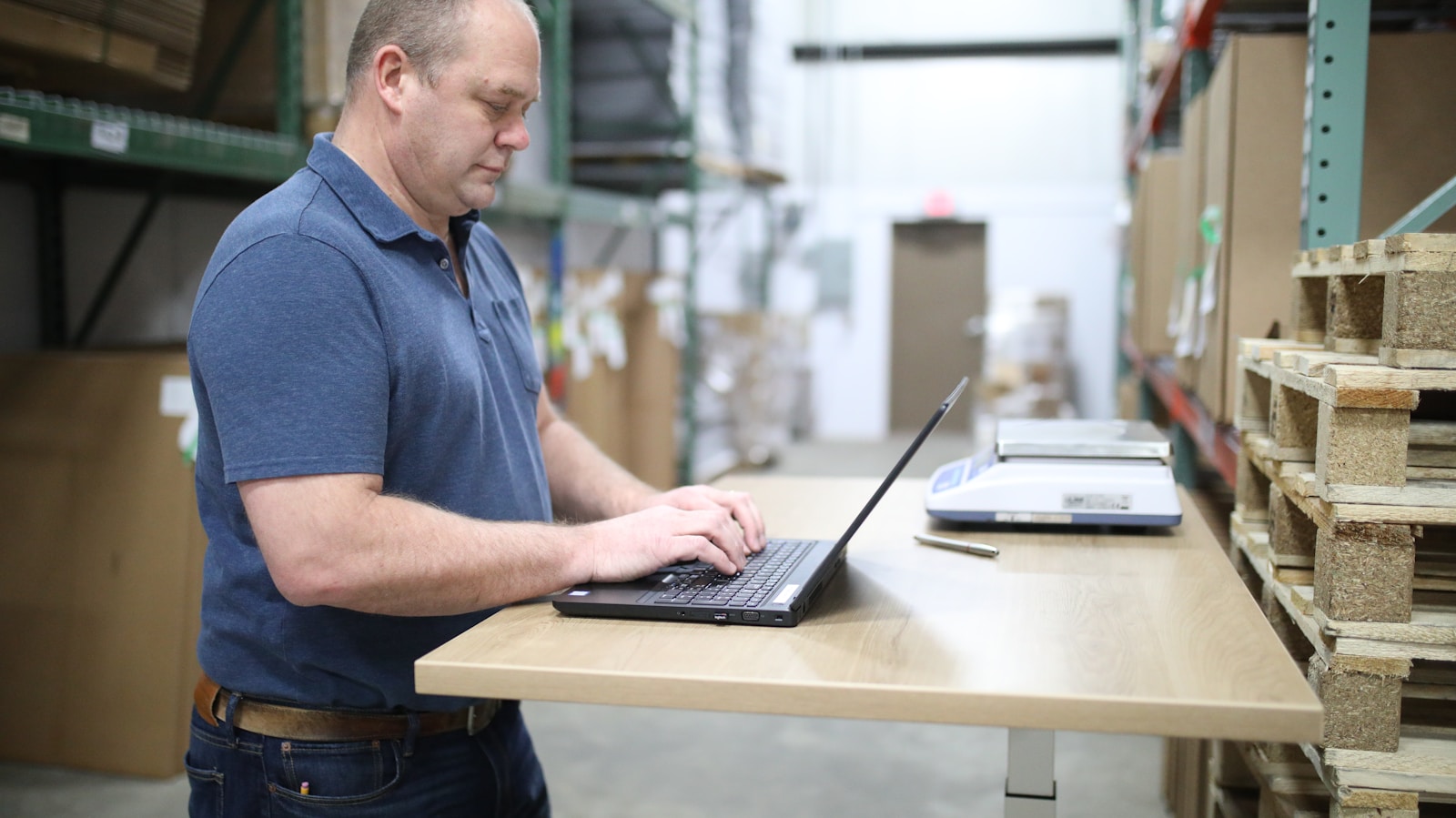 Find Work man in blue polo shirt using laptop computer
